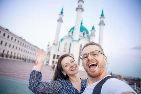 Couple tourist man and woman make selfie on background sunset Kul Sharif Mosque islam Kazan Kremlin. Concept tourism freedom muslim with religionの写真素材