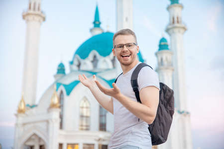 Happy tourist man with backpack smiling on background of Kul Sharif Mosque Kazan Kremlin. Concept Travel Russiaの写真素材