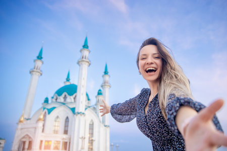 Happy young woman tourist make selfie photo on background of Kul Sharif Mosque Kazan Kremlin. Concept Travel Russiaの写真素材