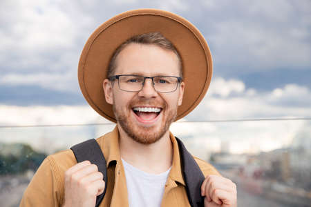 Portrait smile young man tourist in brown hat and glasses with backpack, concept travelの写真素材