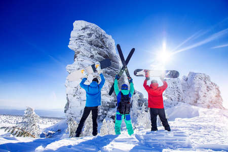 Snowboarders, skier stands with ski and snowboard in hands background blue sky with sun light. Concept freeride extreme, team Sheregesh resortの写真素材