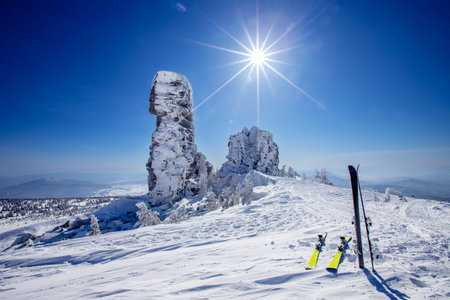 Ski and snowboard background blue sky with sun light frozen rocks, Sheregesh ski resort. Concept...