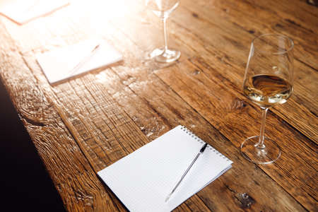 Concept sommelier tasting white wine, row glasses with alcohol and notepad on table, top viewの写真素材
