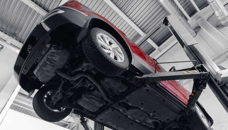 Car service garage. Auto on lift and engine oil is drainedの写真素材