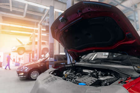 Concept maintenance and oil change. Open hood and disassembled engine in car service with sun lightの写真素材