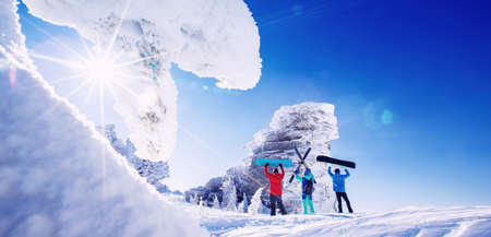 Banner sport team skier and snowboarders stands with ski and snowboard in hands, background blue sky with sunの写真素材