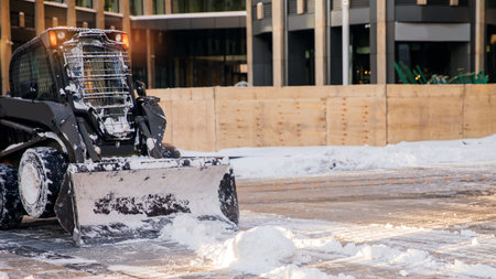 City service cleaning snow winter excavator tractor after snowstorm yard sunlight banner