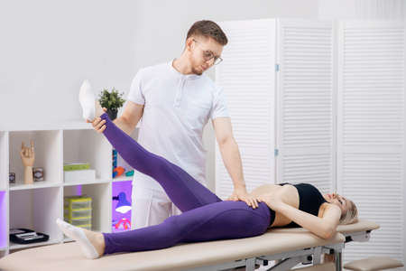 Concept sports massage for athlete woman. Osteopath therapist working with legs muscle after workoutの写真素材