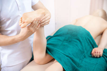 Concept sports massage for woman. Osteopath therapist working with legs muscle athlete after workout.の写真素材