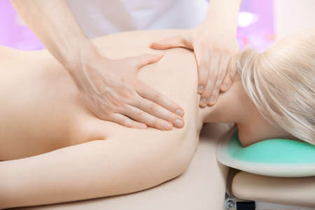 Closeup of hands male doctor osteopath massage of neck for woman in clinicの写真素材