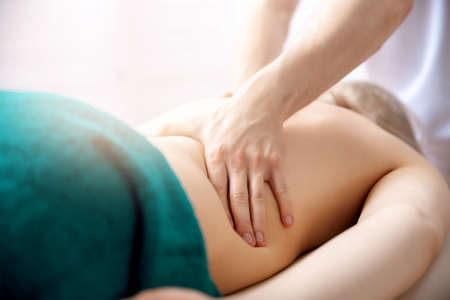 Young woman relaxing with hand professional back massage beauty spaの写真素材
