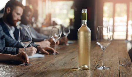 Banner people tasting white wine in restaurant and making notes degustation cardの写真素材