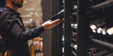 Banner Sommelier Bartender man at wine shop full of bottles with alcohol drinksの写真素材