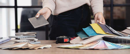 Concept banner study architect, interior design. Woman designer work on laptop workplace, sets of furniture upholstery, wall paint, ceramic tilesの写真素材