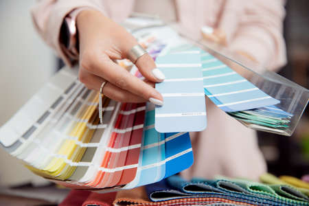 Closeup hand of woman decorator, interior and graphic designer, architect is choosing catalogue colors ral for web project.の写真素材