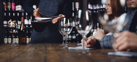Banner tasting red wine in restaurant under guidance of sommelierの写真素材