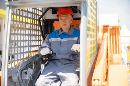 Loader man driver close-up in cab, summer dayの写真素材