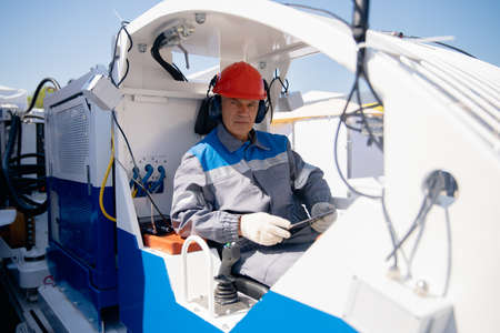 Man engineer uses tablet computer to work at open pit coal miningの写真素材