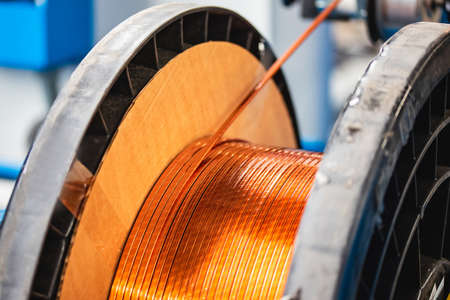 Production of copper wire, bronze cable in reels at factory with lightの写真素材