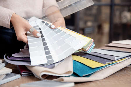 Woman interior designer, decorator chooses fabrics for furniture upholstery, curtains in textile set for for apartment projectの写真素材