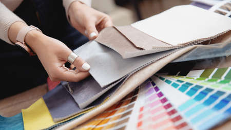 Woman interior designer, decorator chooses fabrics for furniture upholstery, curtains in textile set for for apartment projectの写真素材
