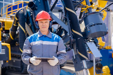 Concept smart online Industry. Offshore worker inspect with tablet drilling rig for exploration of minerals for oil, gas and artisan waterの写真素材