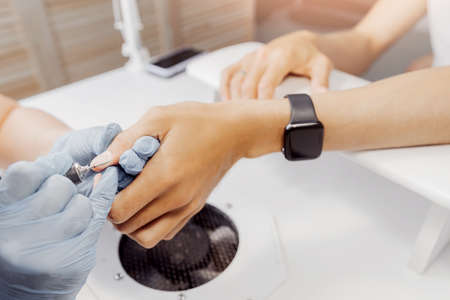 Closeup hands of young man gets professional manicure in spa salonの写真素材