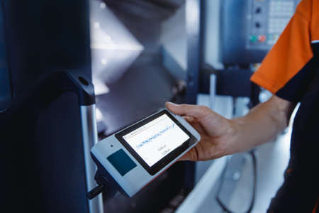 Industrial worker measures roughness and frequency of machined part after lathe with instrumentの写真素材