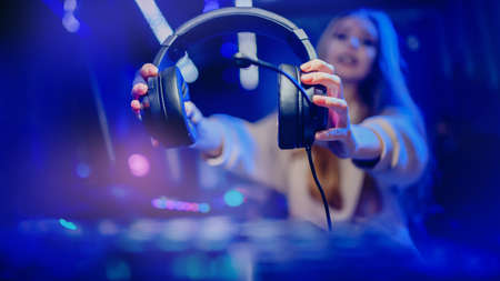 Woman hand hold headphones with microphone for video games and cyber sports on neon backgroundの写真素材