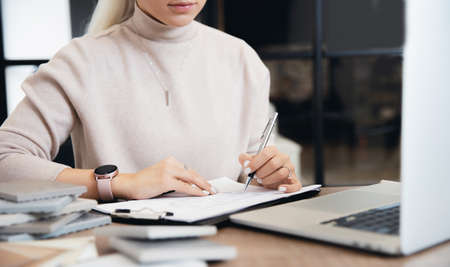 Happy young woman is online education interior design course behind laptop. Concept choosing profession of Internet designerの写真素材