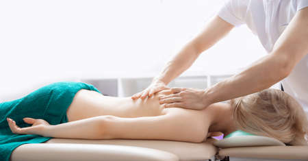 Concept physiotherapy massage for rehab sport injury athlete back. Doctor osteopath use therapy for woman in clinicの写真素材