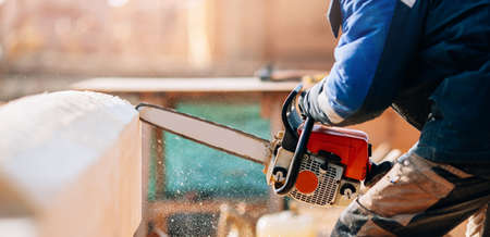 Worker carpenter builder working on roof house of log structure background blue skyの写真素材