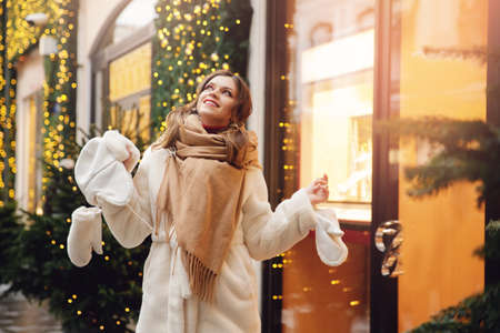 Portrait beauty girl wearing stylish white warm clothes, bokeh lights. Concept winter holidays Red square Moscow, Russiaの写真素材