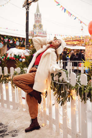 Winter portrait young beautiful happy smiling woman in wearing stylish warm clothes, bokeh lights. Concept travel Christmas holidays Europe cityの写真素材