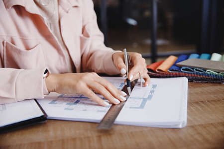 Closeup Hand Professional Architect and interior designer working in workplace, draw apartment plan with art toolsの写真素材