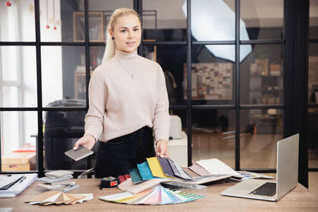 Concept choosing profession of Internet designer. Happy young woman is online education interior design course behind laptopの写真素材