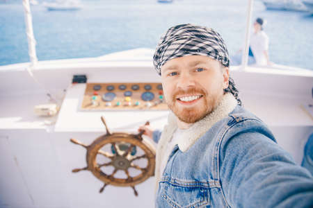 Tourist man on keffiyeh or arabic shawl driver captain of white luxury yacht making selfie. Concept boat rental in Arab Emirates, Egyptの写真素材