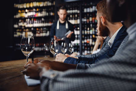 Tasting red wine in restaurant under guidance of sommelierの写真素材