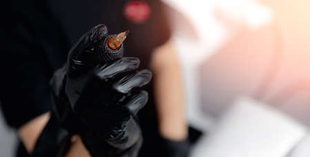 Banner Woman artist holding tattoo machine for permanent makeup or artの写真素材