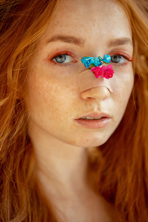 Fashion photo woman extended fake eyelashes for red haired with rose flower faceの写真素材