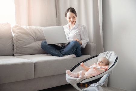 Closeup baby in automatic carrycot, businesswoman working at home office using laptop computer with...