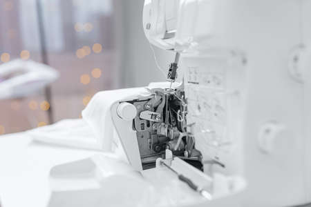 Seamstress woman repair cleans sewing machine, replacement of needle and thread. Concept tailor workplaceの写真素材