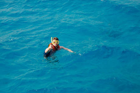Traveler man swimmer with mask and snorkel is engaged in snorkeling in red sea, turquoise clear water. Concept Travel Egypt Hawaiiの写真素材