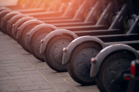 Set Electric scooters are in parking lot ready for rent, sun lightの写真素材