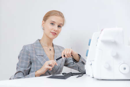 Concept businesswoman tailor. Female seamstress sitting working place with sewing toolsの写真素材