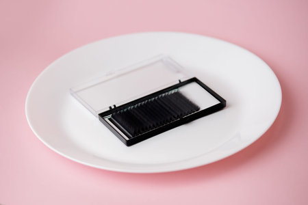 Set box artificial black lashes pink isolated background, eyelash extension