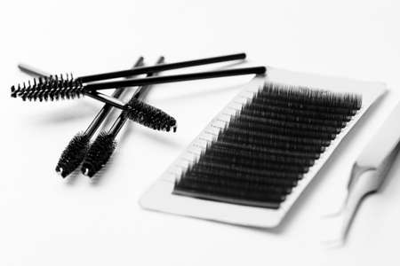 Set black lashes and brush tweezers in white isolated background, eyelash extension conceptの写真素材