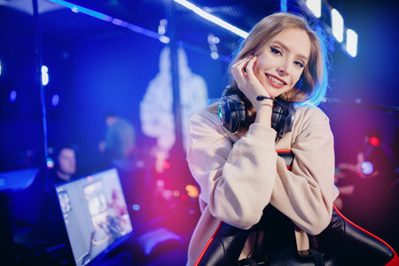 Portrait young woman happy pro gamer having live stream and playing in online video game to...