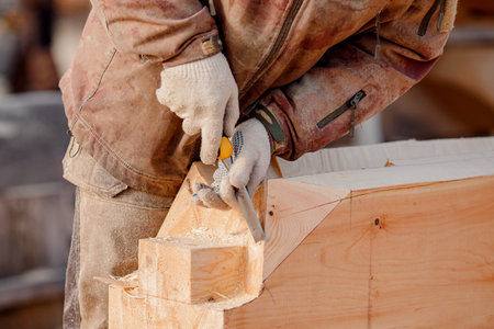 Industrial carpenter working with log, construction frame building site of house made of woodの写真素材