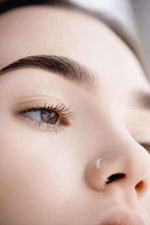 Young woman with beautiful eyebrows. Correction of brow hair in beauty salonの写真素材